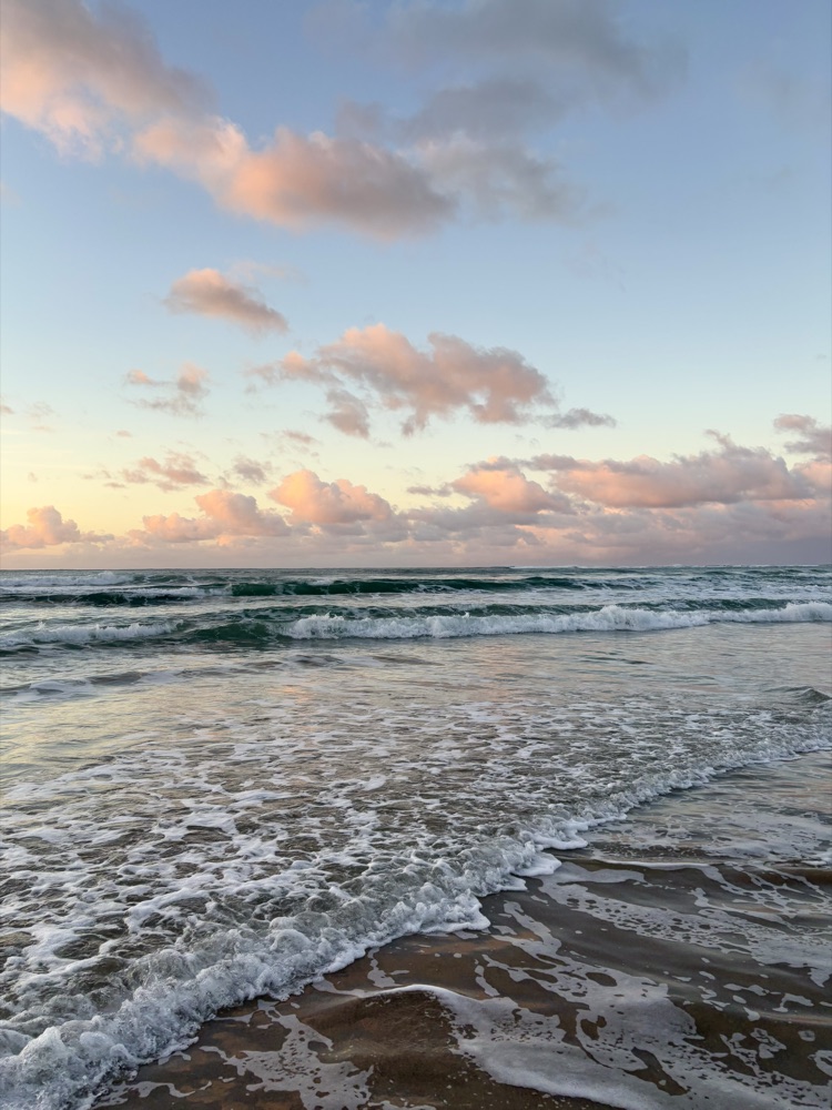 Waves rolling onto a beach at sunset